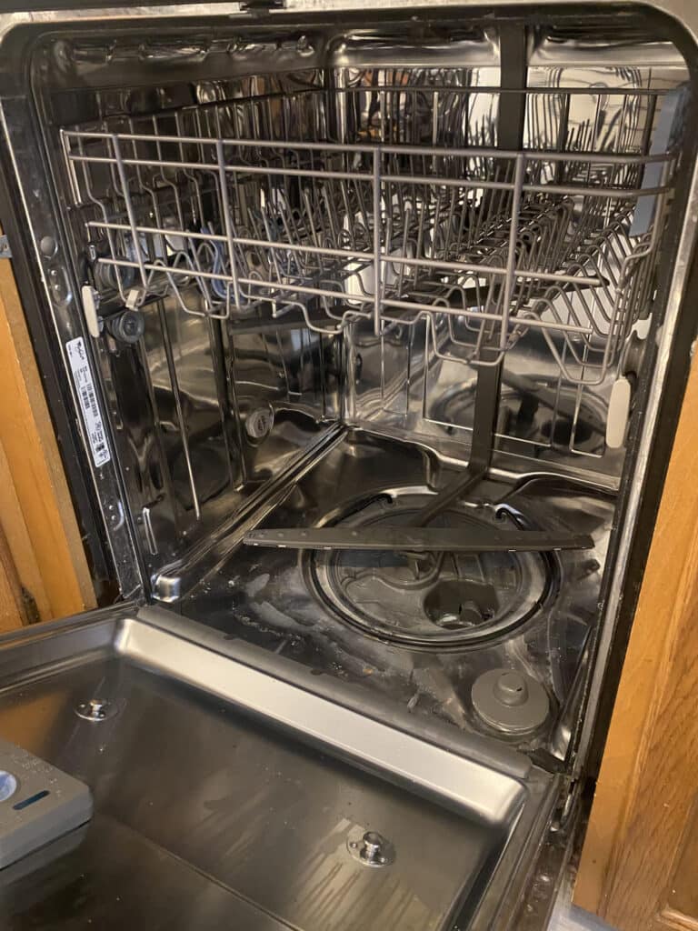Open dishwasher with the interior tub and racks visible