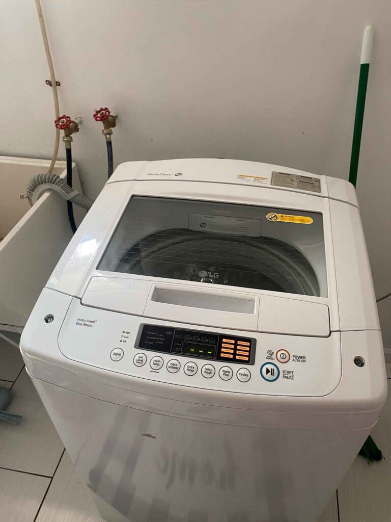 White top-loading washing machine with a glass lid