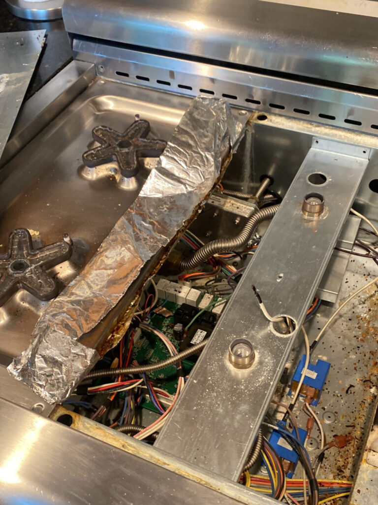 Gas range with the control panel removed and internal components visible